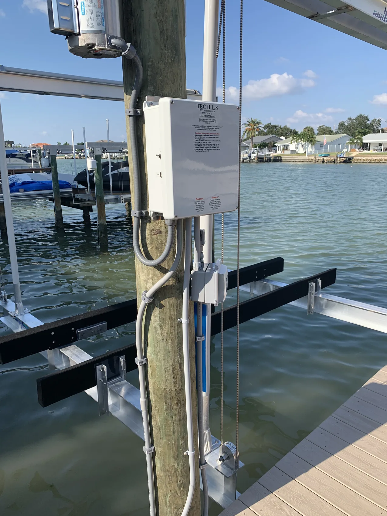 Boat lift motor, control box, and wiring on a dock piling in Pinellas County, FL