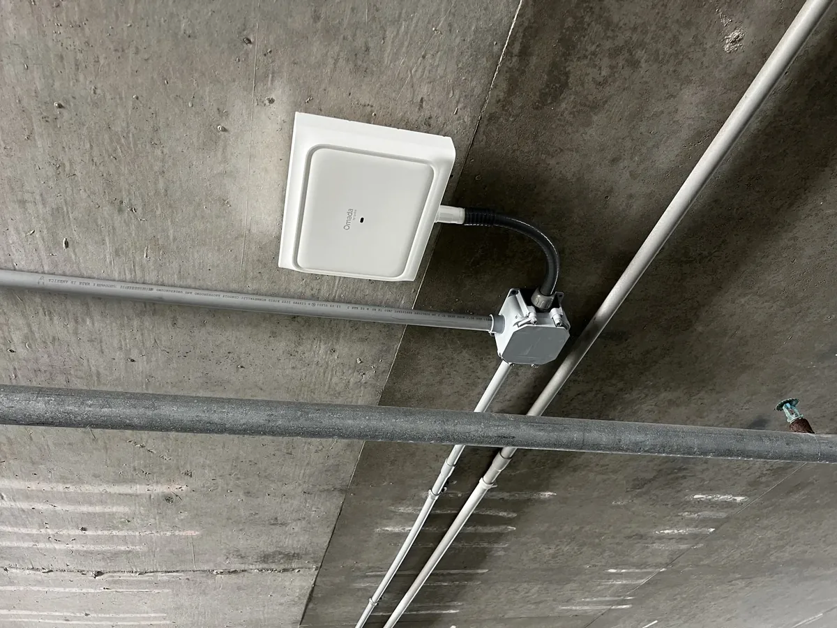 Commercial WiFi access point mounted to a concrete ceiling and fed through conduit by Far Out Design in Pinellas County, Florida.
