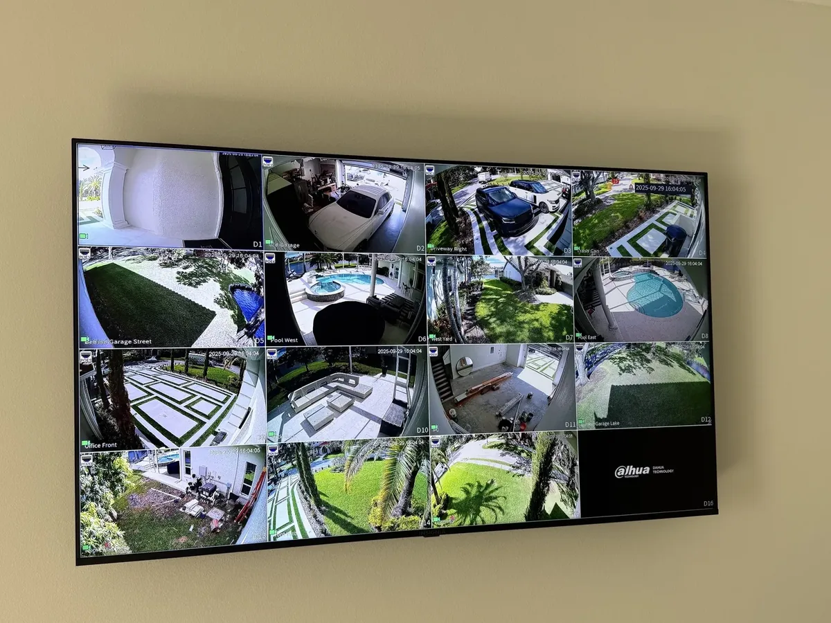 Wall-mounted 16-channel security camera display showing live views of a property Far Out Design wired in Pinellas County, Florida.