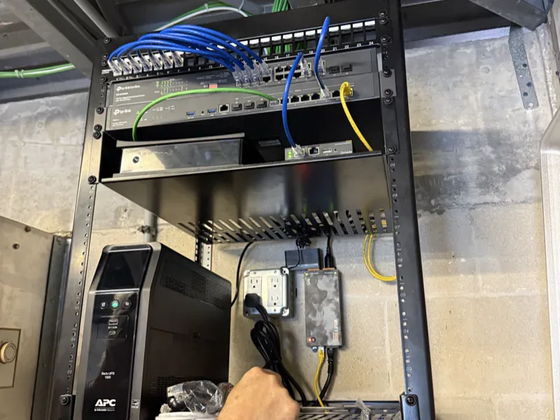 Structured cabling terminated on a 24-port patch panel with Cat6 patch cords, network switch and rack UPS, installed by Far Out Design in Pinellas County, Florida.